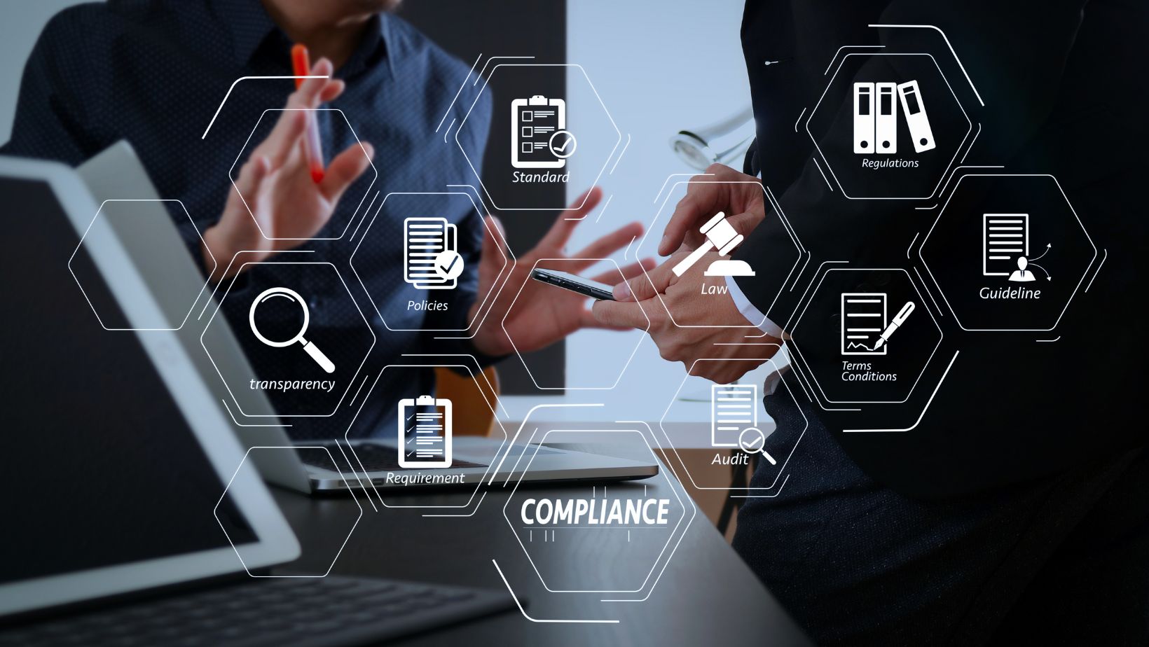 Woman sitting at desk with logos about compliance surrounding her